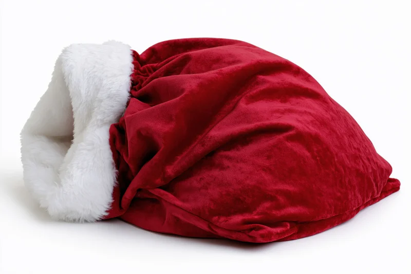 Red velvet santa gift sack lying flat on white background