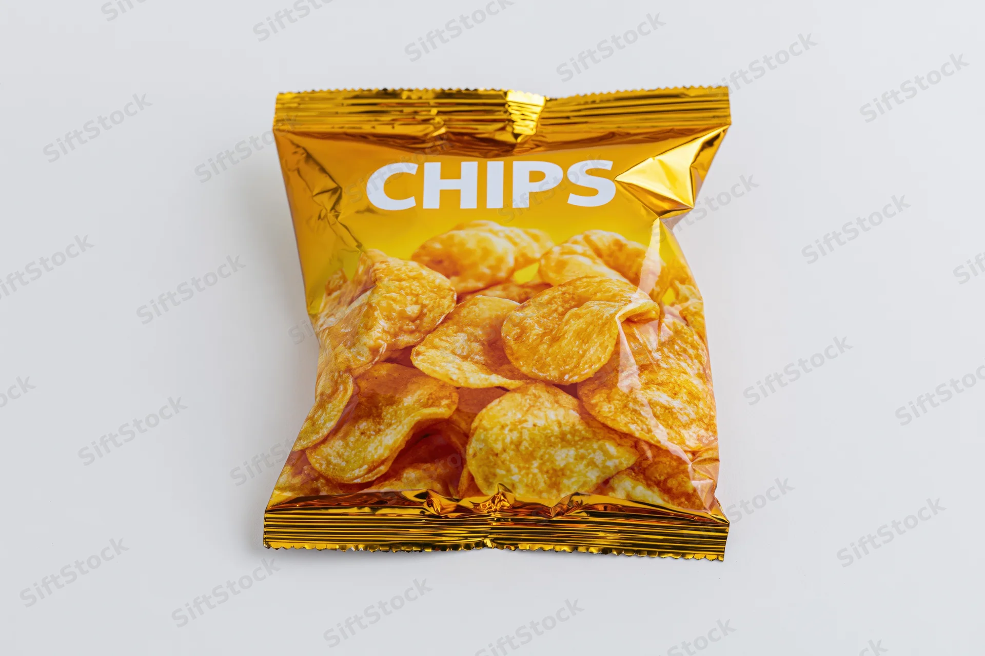 Sealed golden foil snack bag labeled chips on white background