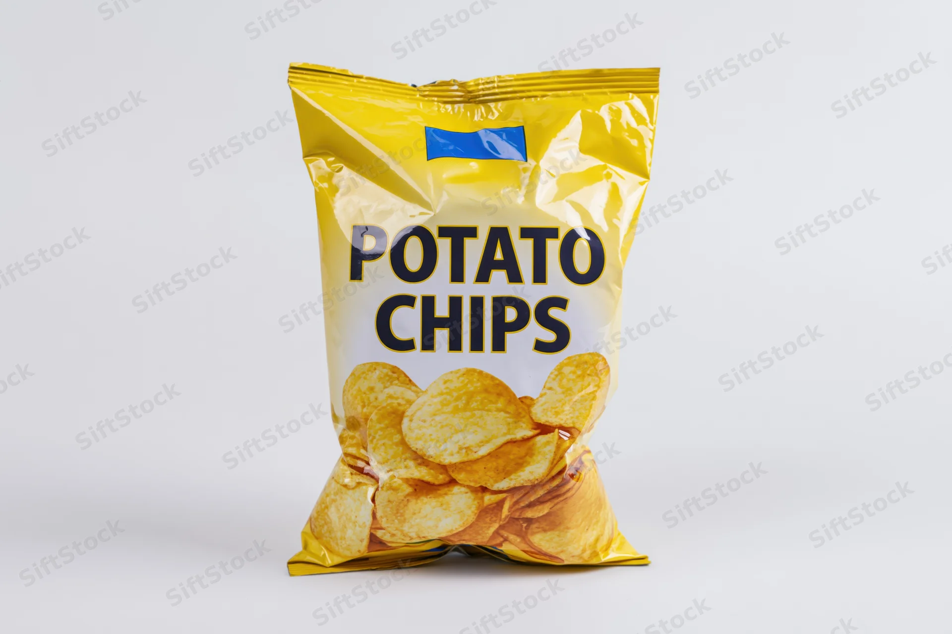 Sealed bag of potato chips standing upright on white background