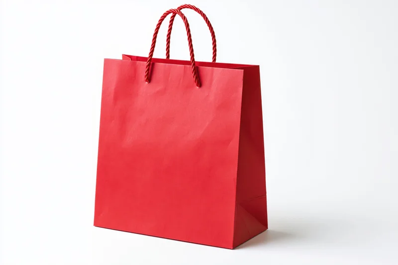 Red glossy paper shopping bag with twisted rope handles on white background