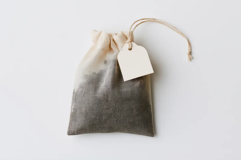 Cotton drawstring tea bag with blank paper tag on white background