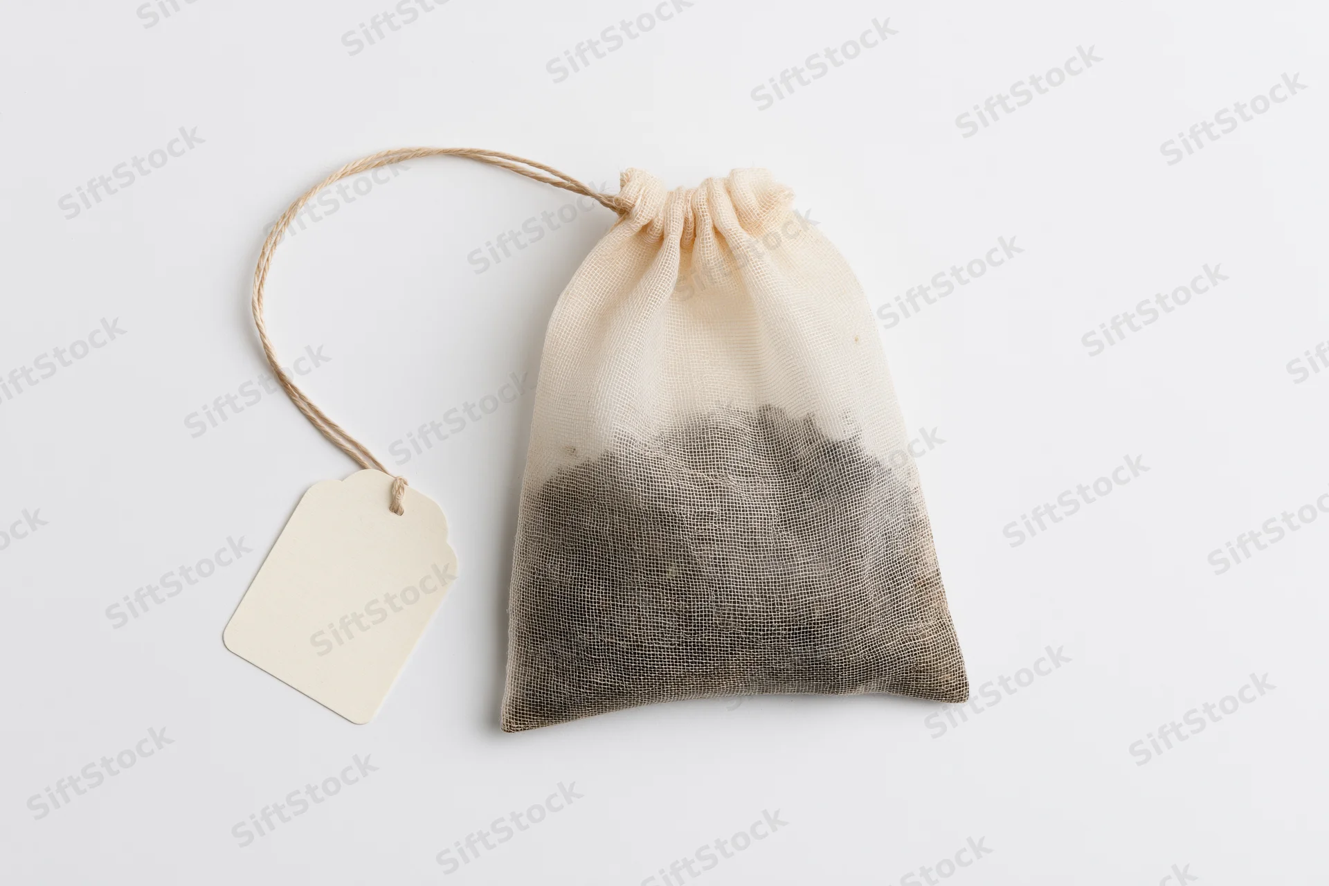 Tea bag with blank paper label attached by string on white background