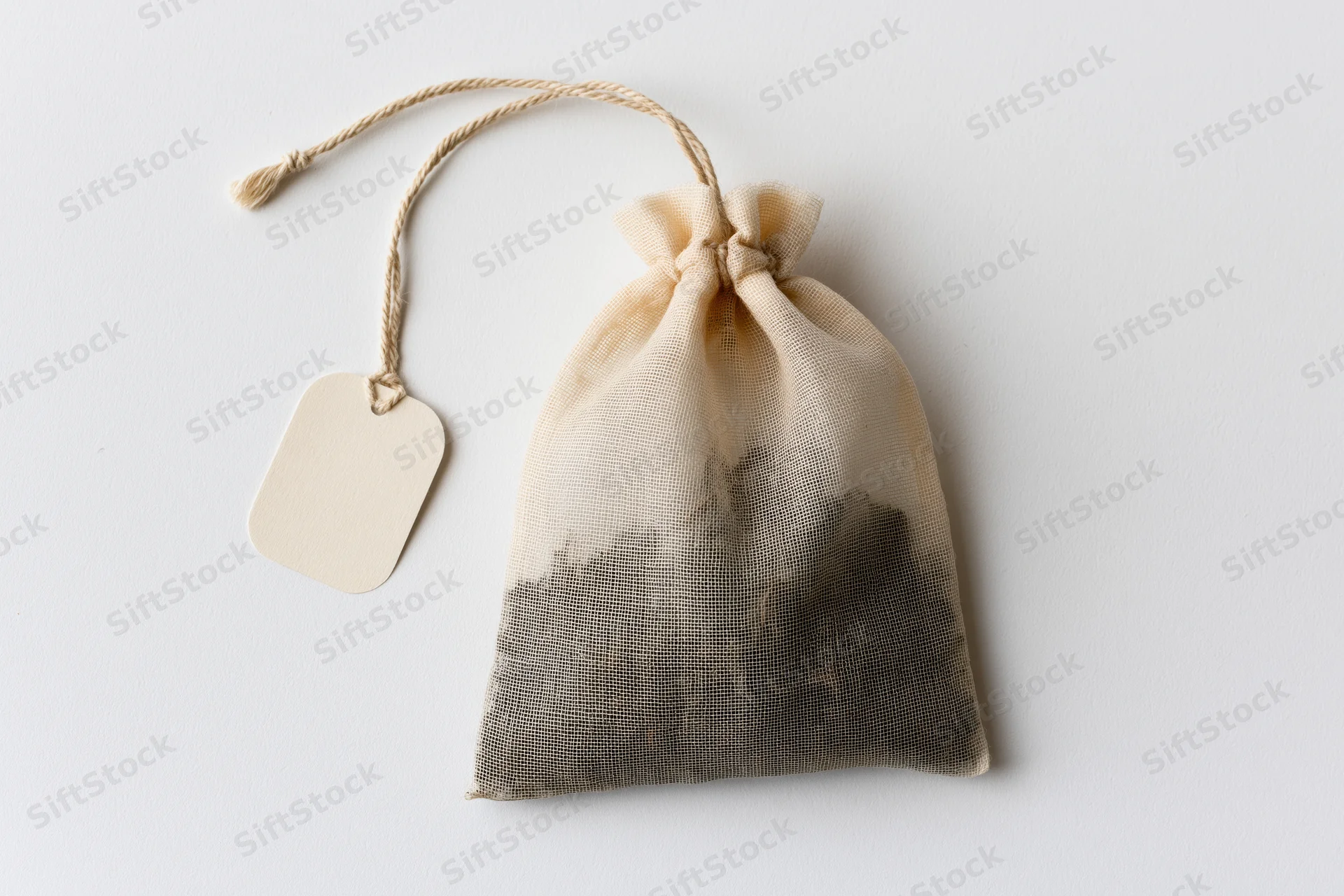 Single tea bag with drawstring and blank tag on white background