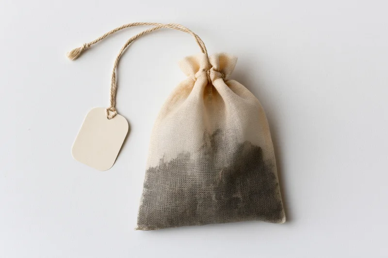 Single tea bag with drawstring and blank tag on white background