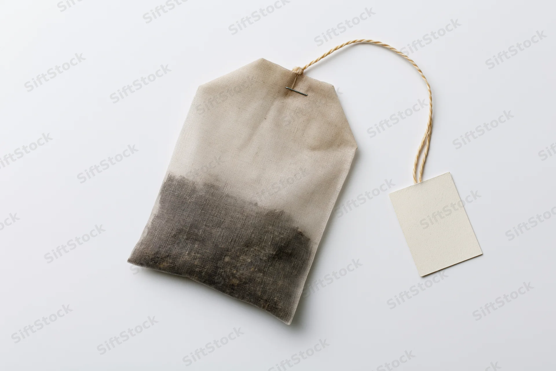 Unused tea bag with paper tag on white background
