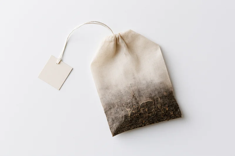 Unused tea bag with square paper tag on white background