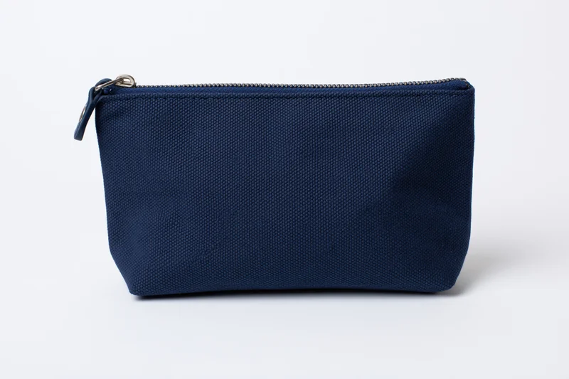 Navy blue canvas cosmetic pouch with top zipper on white background