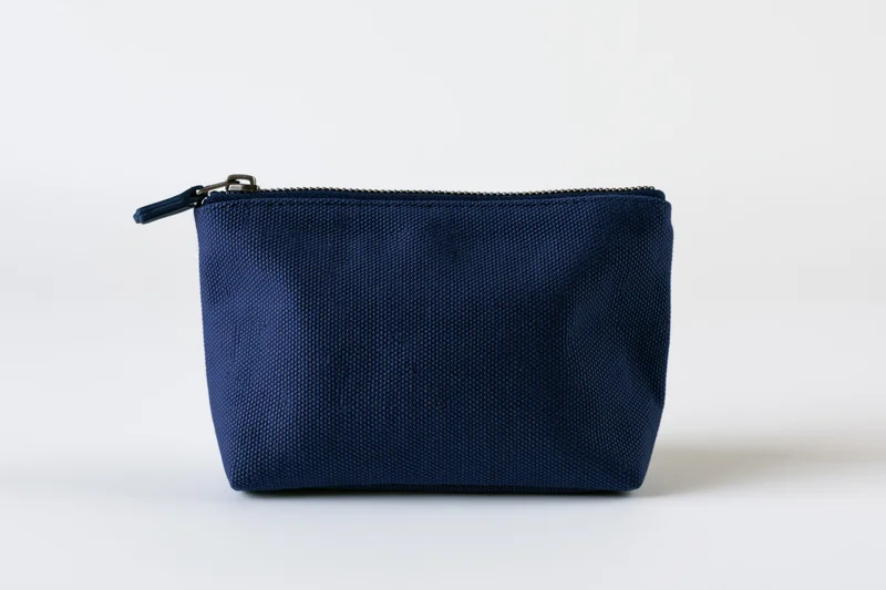 Navy blue canvas cosmetic pouch with top zipper on white background