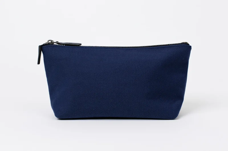 Navy blue canvas cosmetic pouch with top zipper on white background