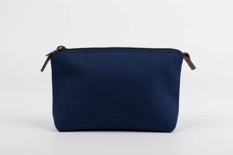 Navy canvas cosmetic pouch with top zipper on white background