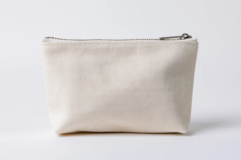 Small rectangular canvas zipper pouch sitting upright on white background