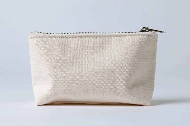 Small rectangular canvas zipper pouch sitting upright on white surface