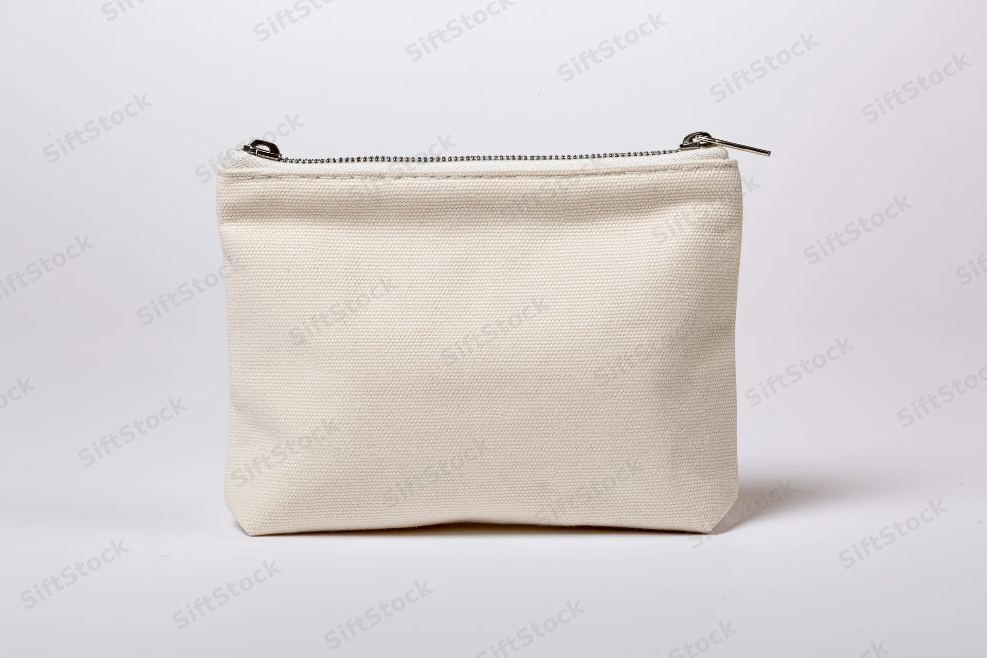 Small cream canvas pouch with zipper standing upright on white background