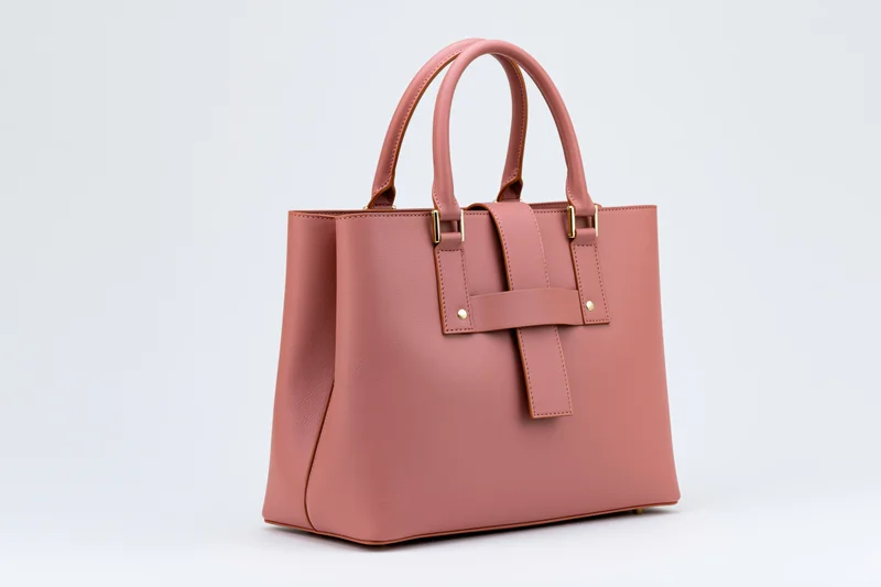 Structured pink leather tote handbag with dual top handles on white background