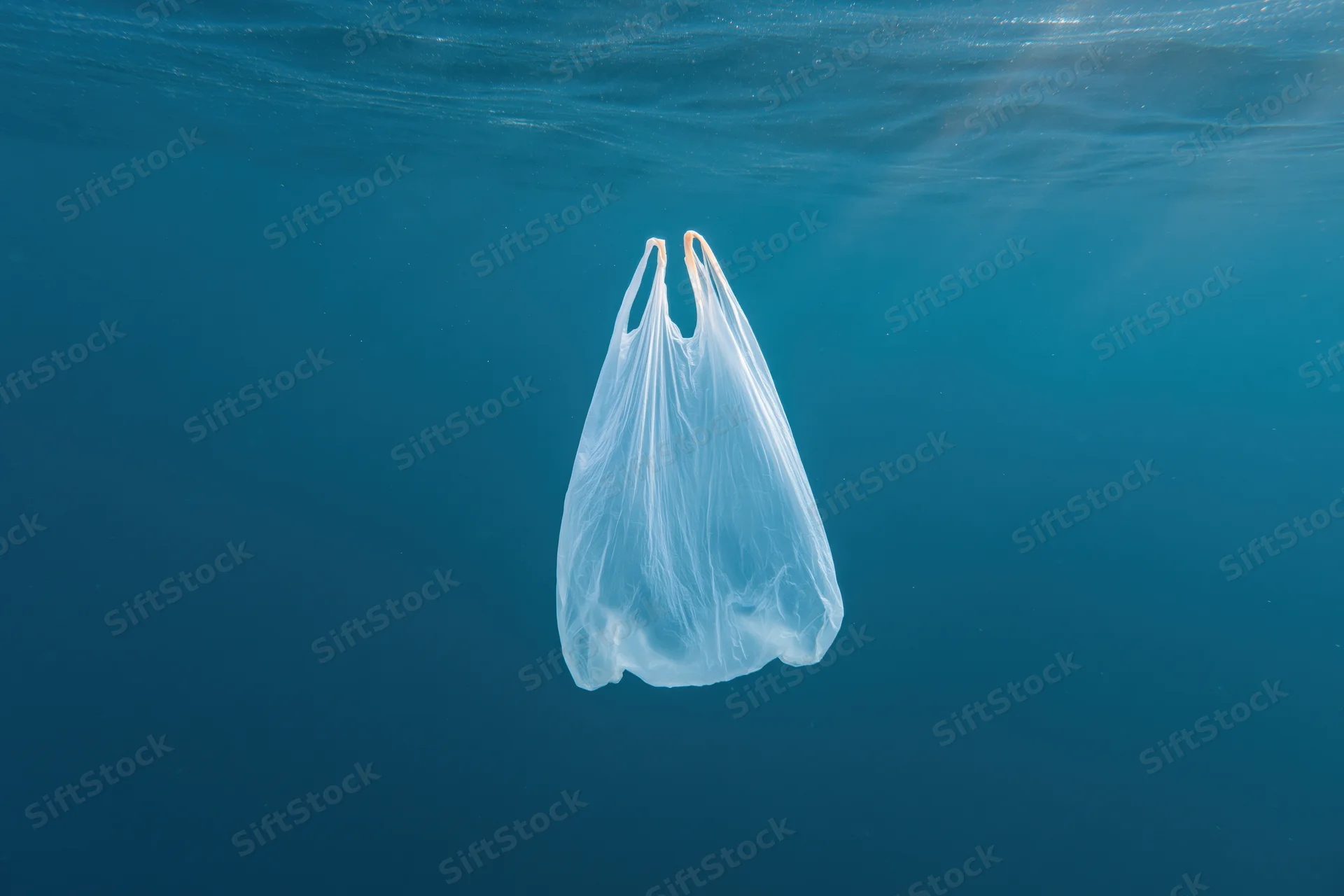 Translucent white plastic bag drifting underwater in the ocean