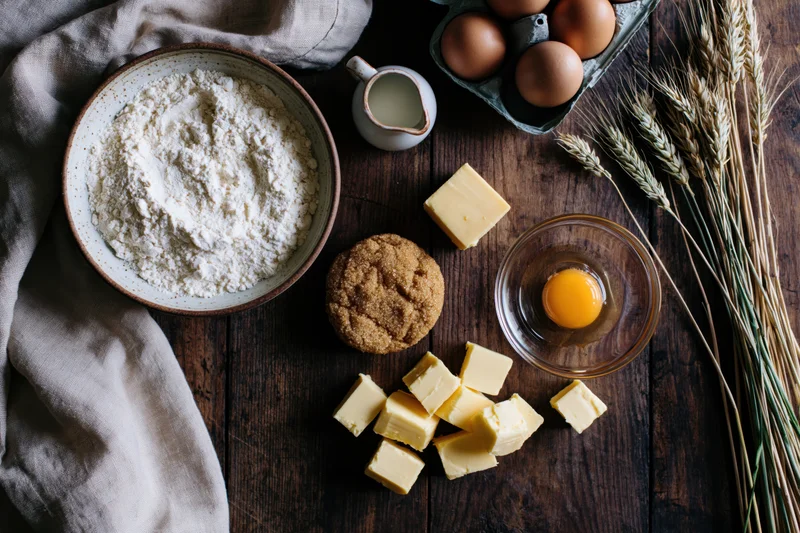 Baking ingredients arranged flat lay on dark wooden table