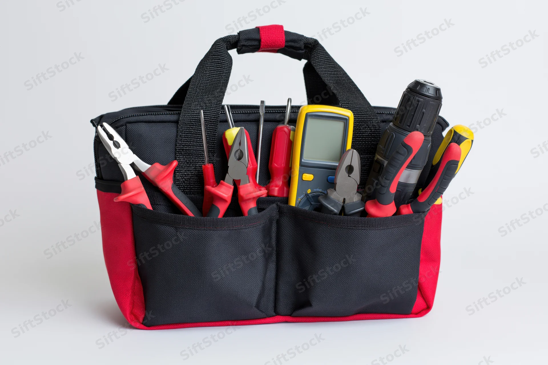Black and red nylon tool bag filled with electrician's hand tools on white background