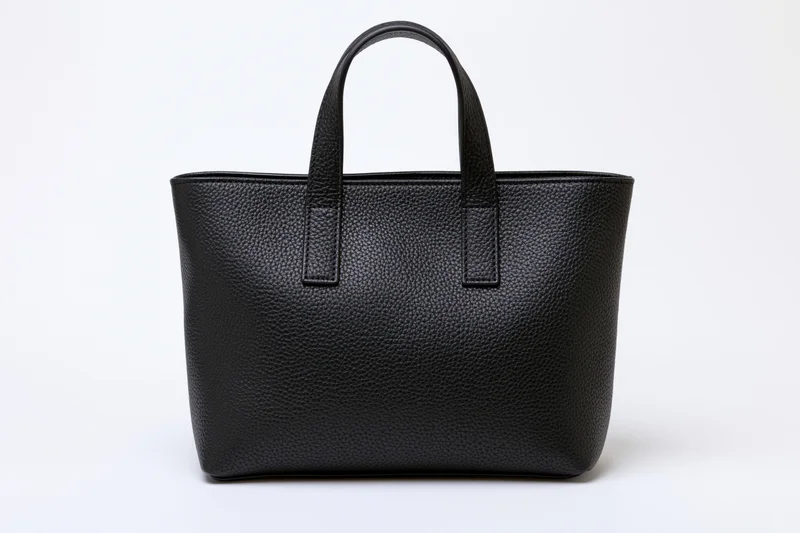 Black pebbled leather tote handbag with two short top handles on white background