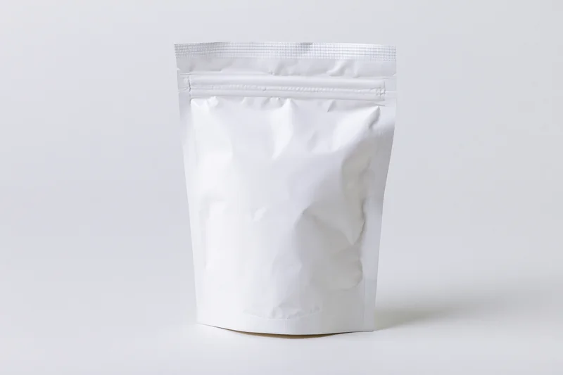 Blank white foil snack pouch standing upright front view on white background