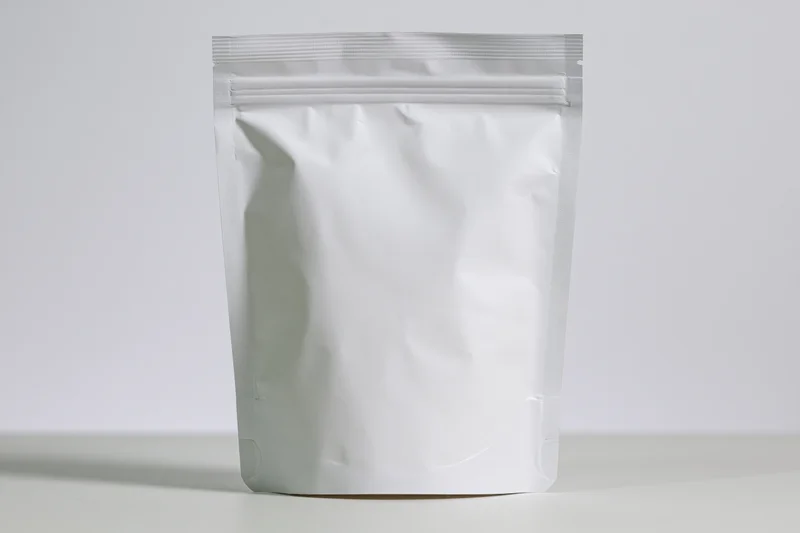 White matte stand-up pouch with zipper seal standing upright on a plain surface