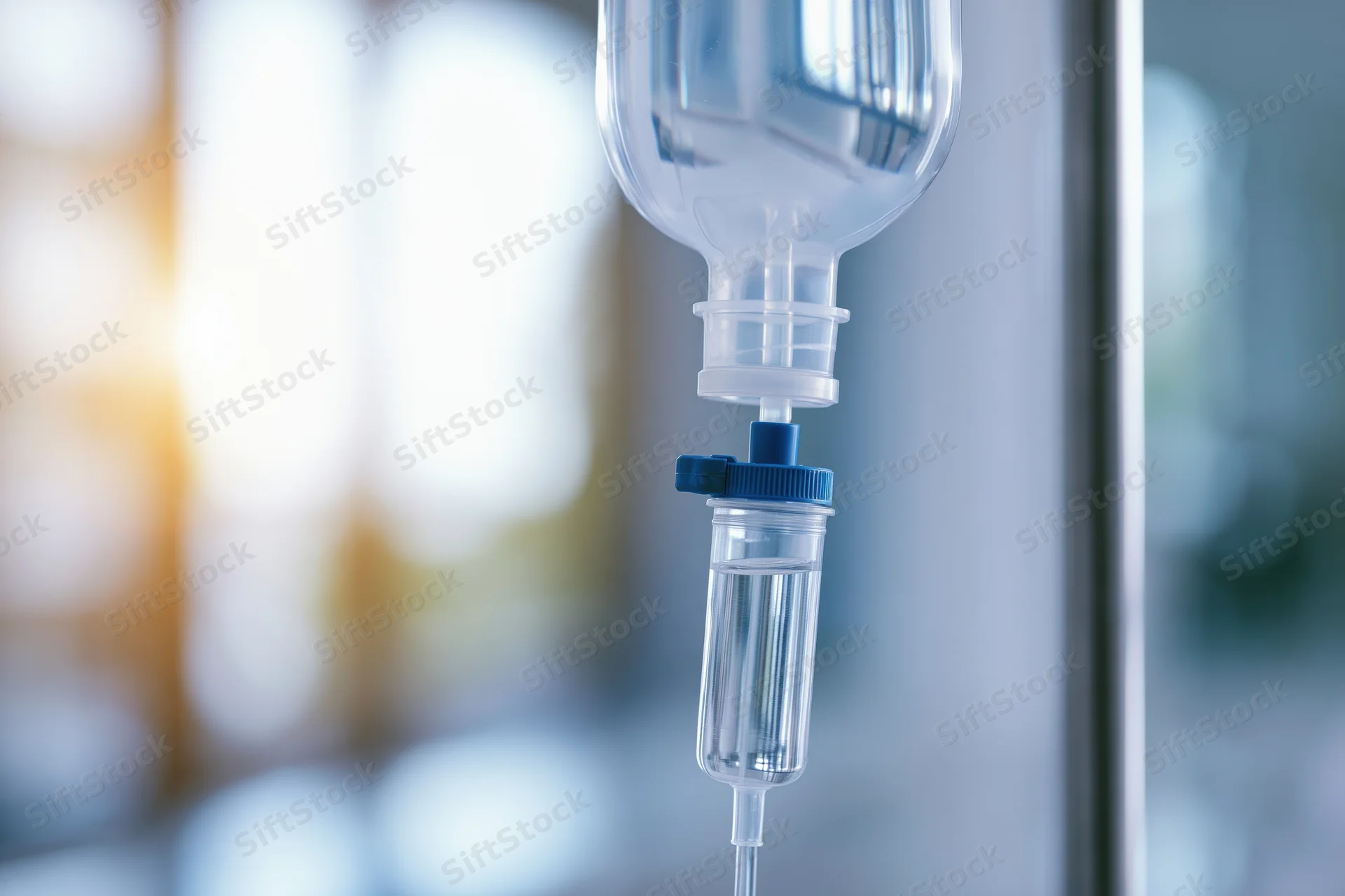 Clear iv saline drip bag hanging on hospital pole close-up