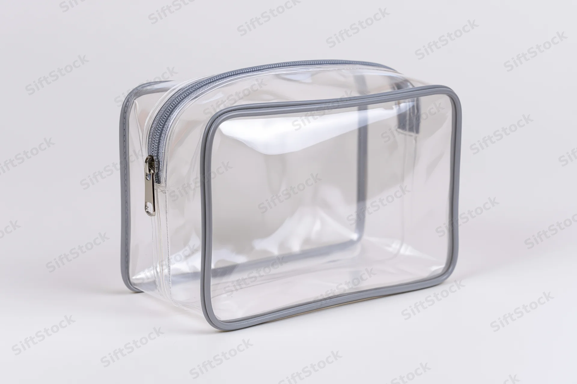 Clear transparent pvc toiletry bag with silver zipper empty on white background