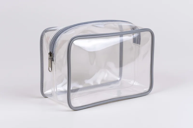 Clear transparent pvc toiletry bag with silver zipper empty on white background
