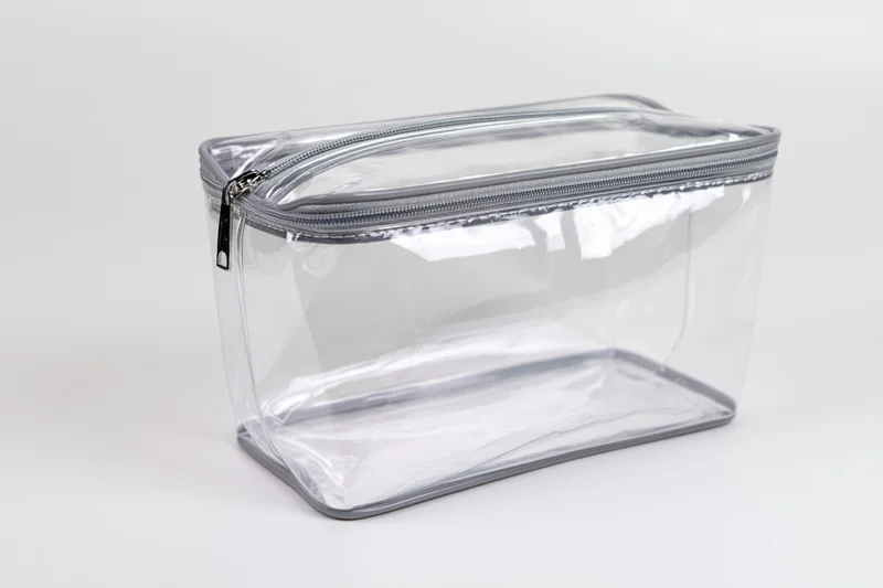 Clear transparent pvc toiletry bag with silver zipper empty on white background
