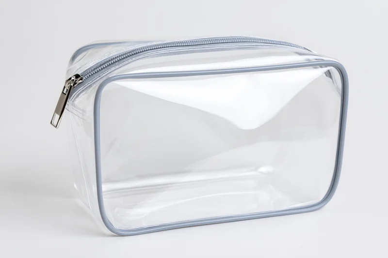Clear transparent pvc toiletry bag with silver zipper empty on white background