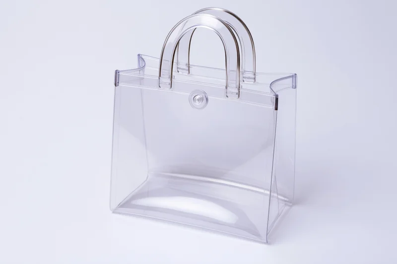 Clear PVC tote bag with rigid loop handles and a round snap