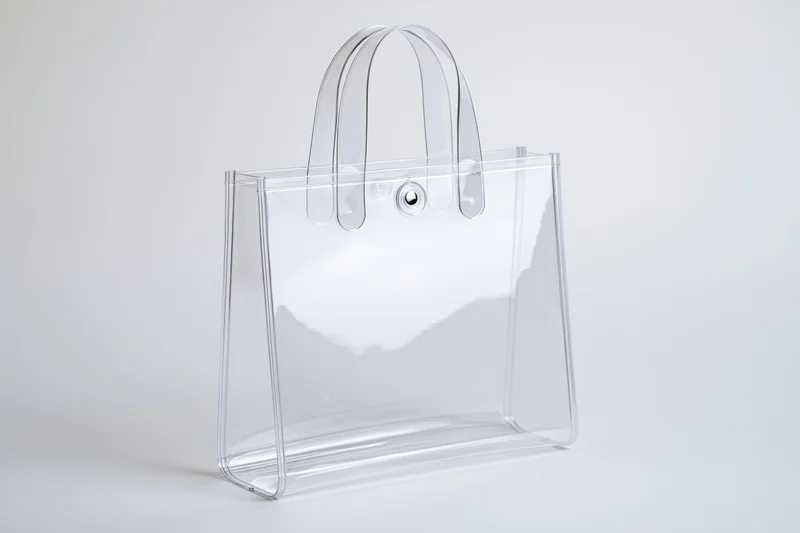 Clear transparent pvc tote bag with rigid loop handles on white background