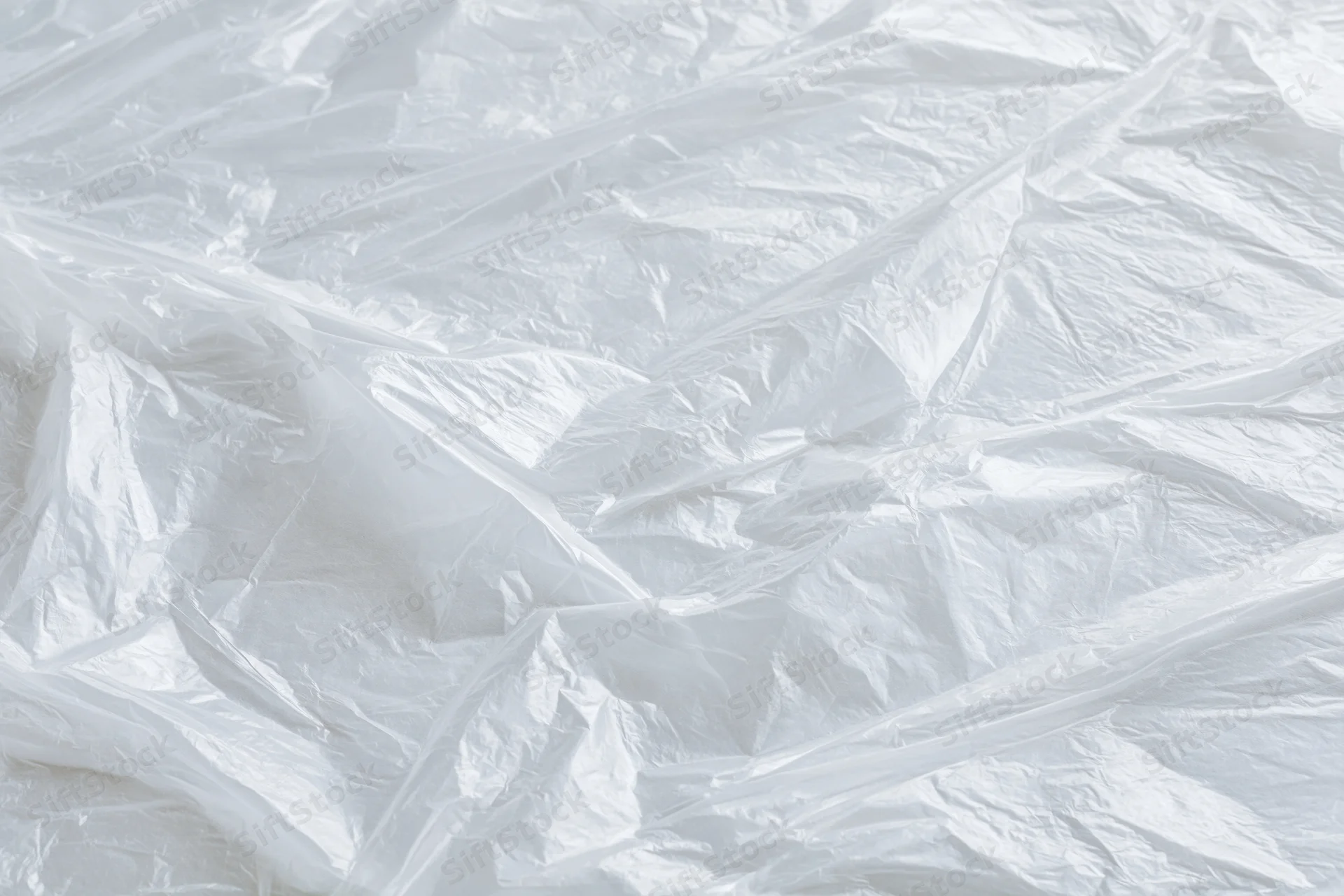 Crumpled clear plastic wrap sheet laid flat in close-up view