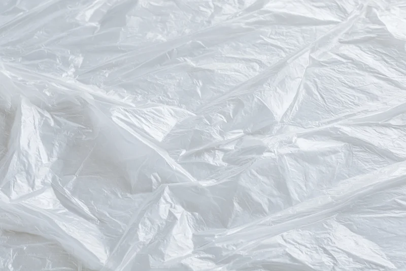 Crumpled clear plastic wrap sheet laid flat in close-up view