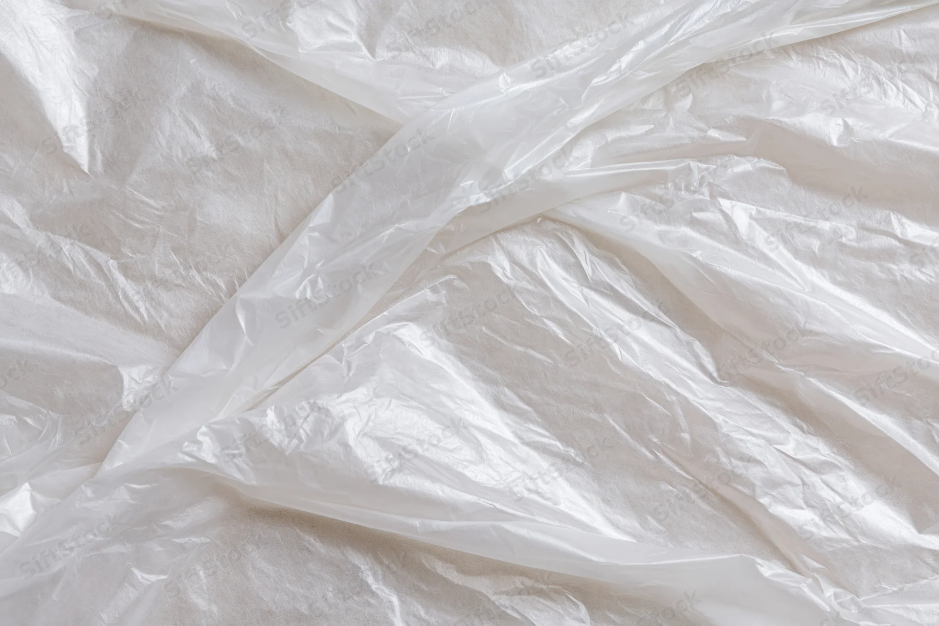 Crumpled clear plastic wrap sheet laid flat in close-up view