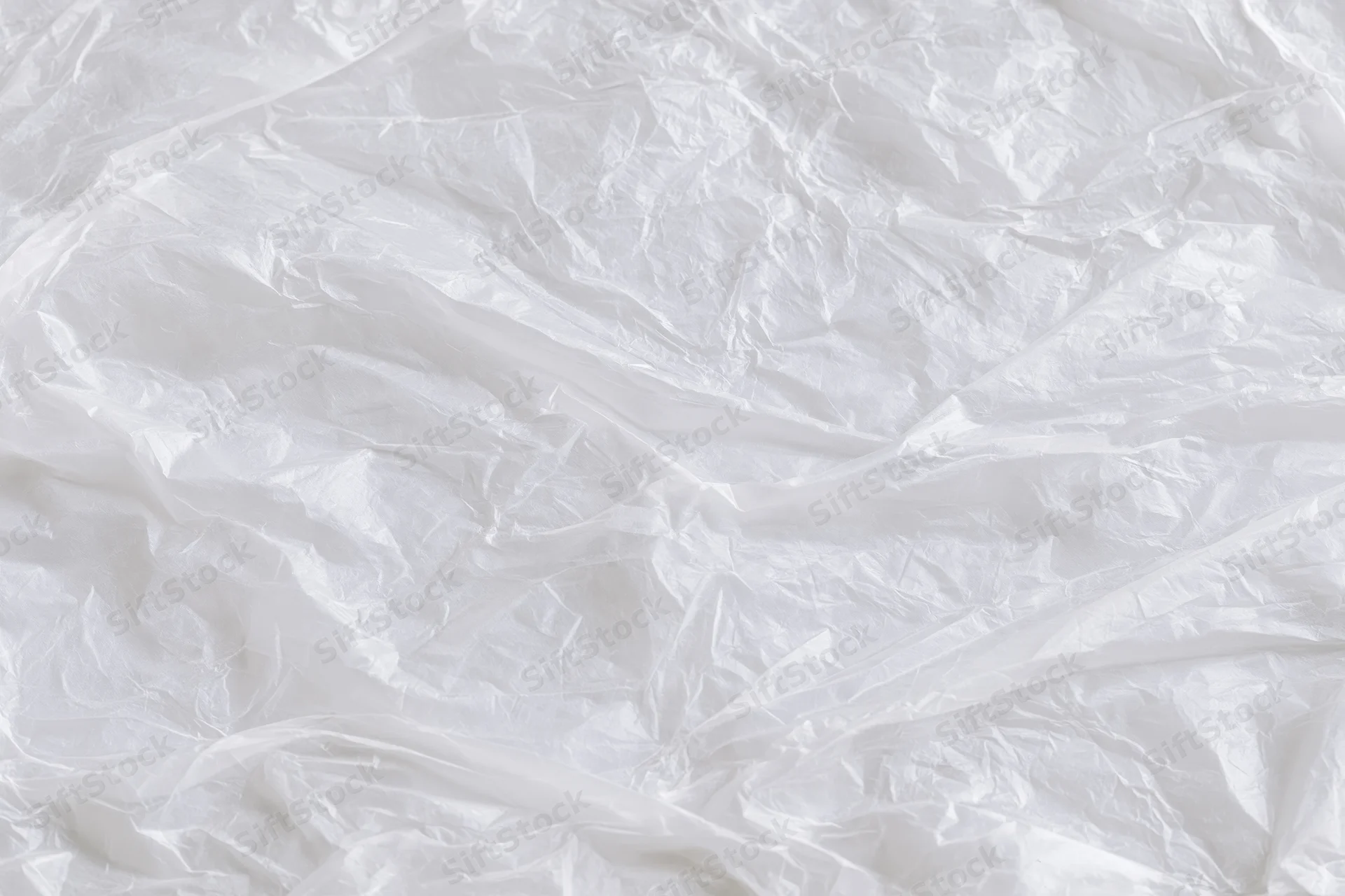 Crumpled clear plastic wrap sheet laid flat as textured background