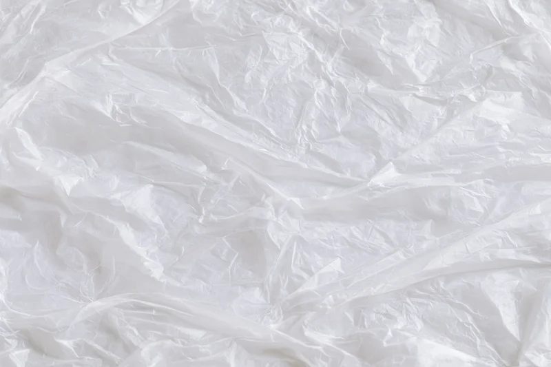 Crumpled clear plastic wrap sheet laid flat as textured background