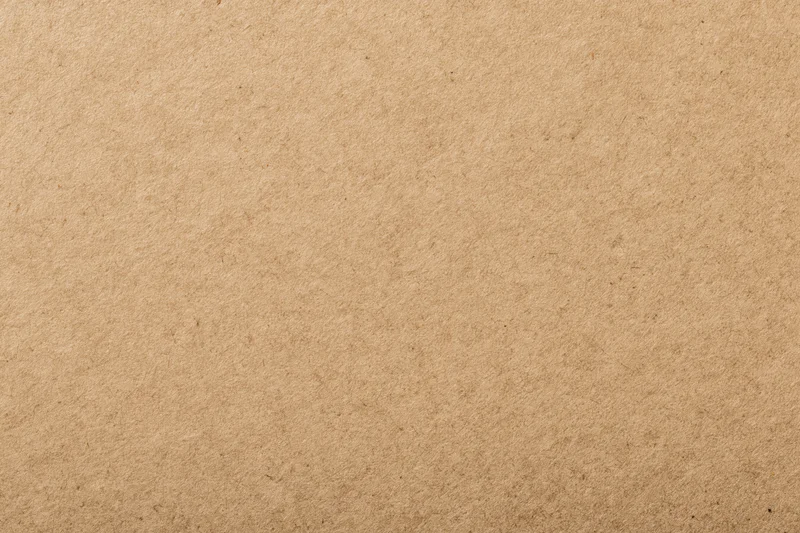 Close-up of a flat sheet of kraft brown recycled paper with visible texture and fibers