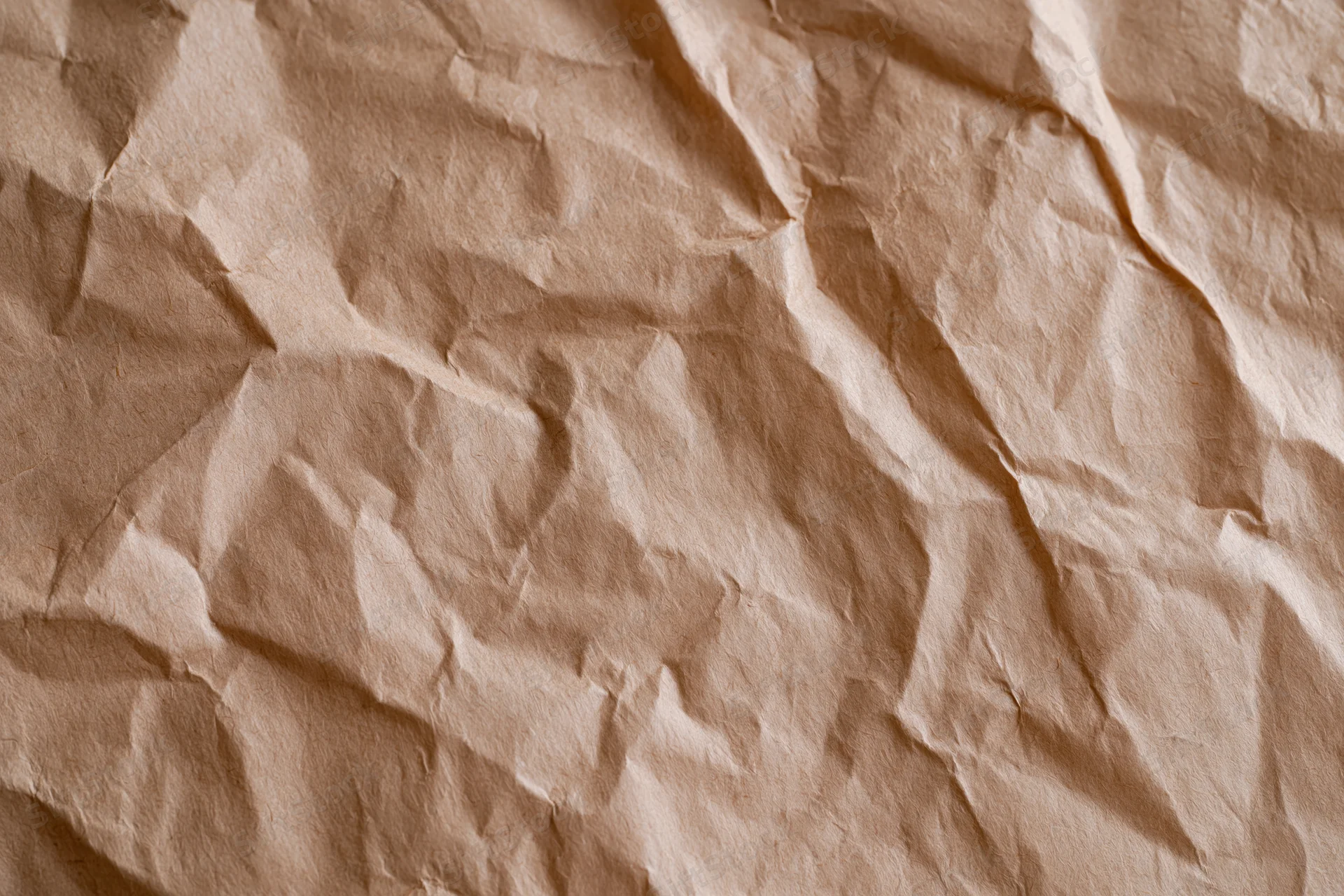 Crumpled kraft brown wrapping paper filling the frame as a textured background