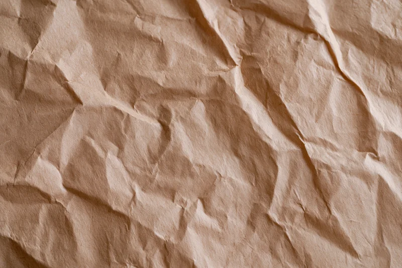 Crumpled kraft brown wrapping paper filling the frame as a textured background