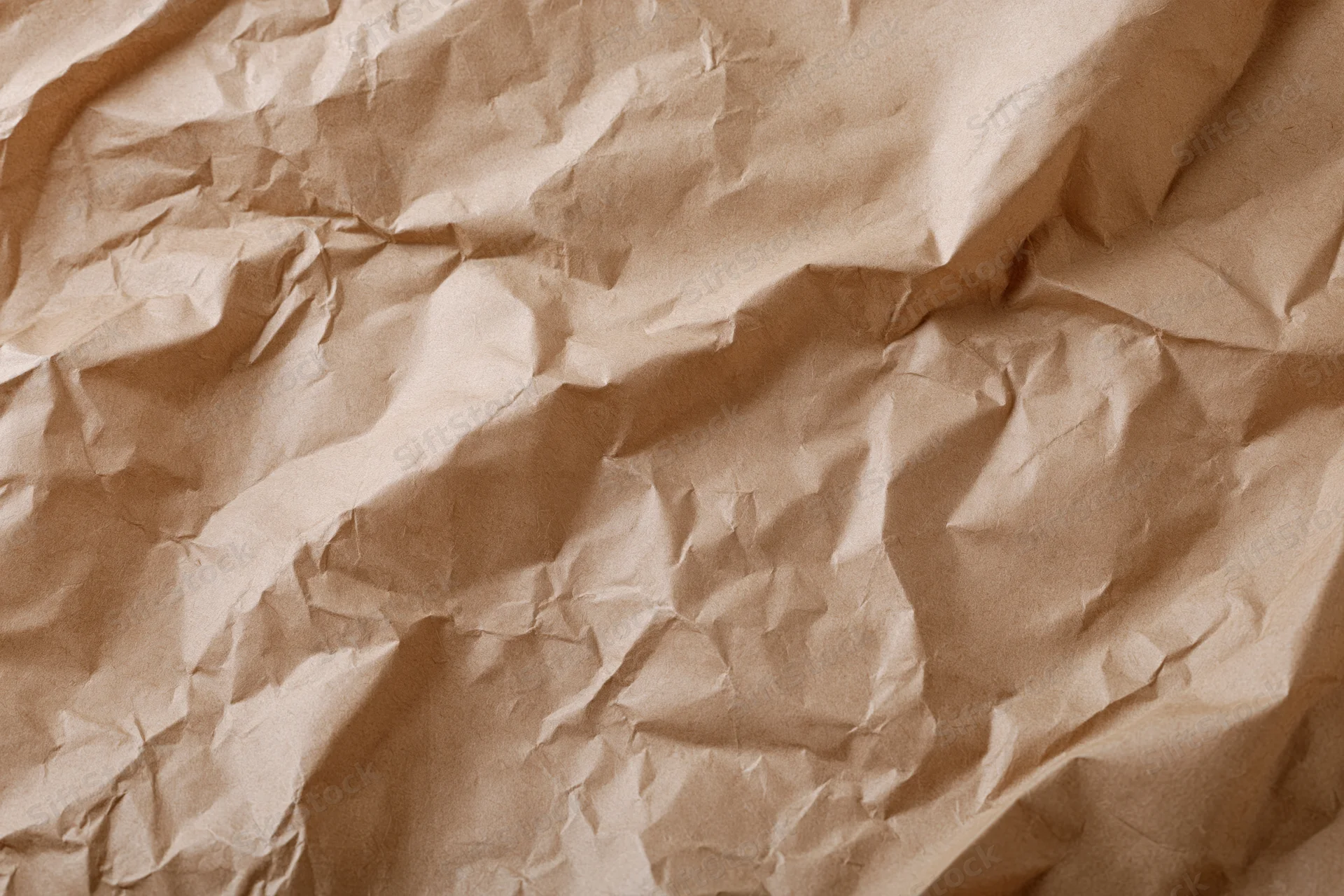 Crumpled kraft brown wrapping paper filling the frame in a flat lay closeup