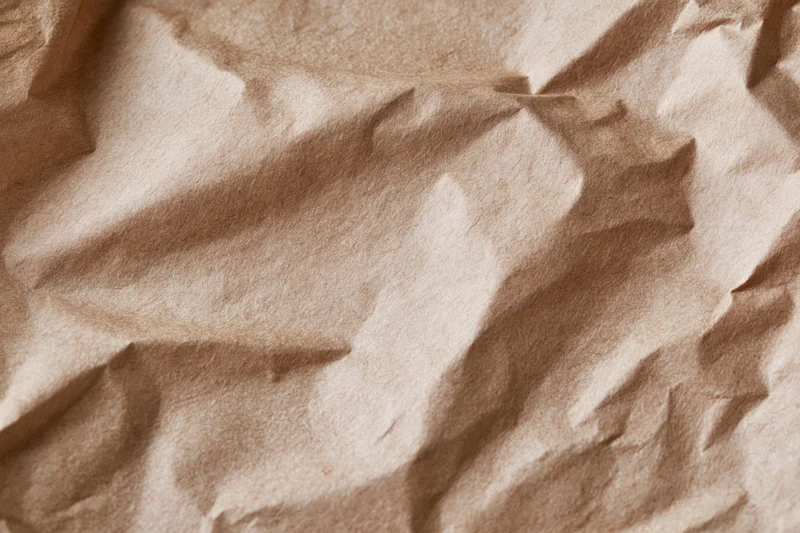 Crumpled kraft brown wrapping paper filling the frame in a flat lay closeup