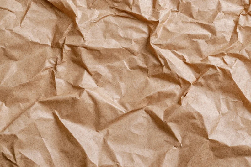 Crumpled kraft brown wrapping paper filling the frame as a textured background