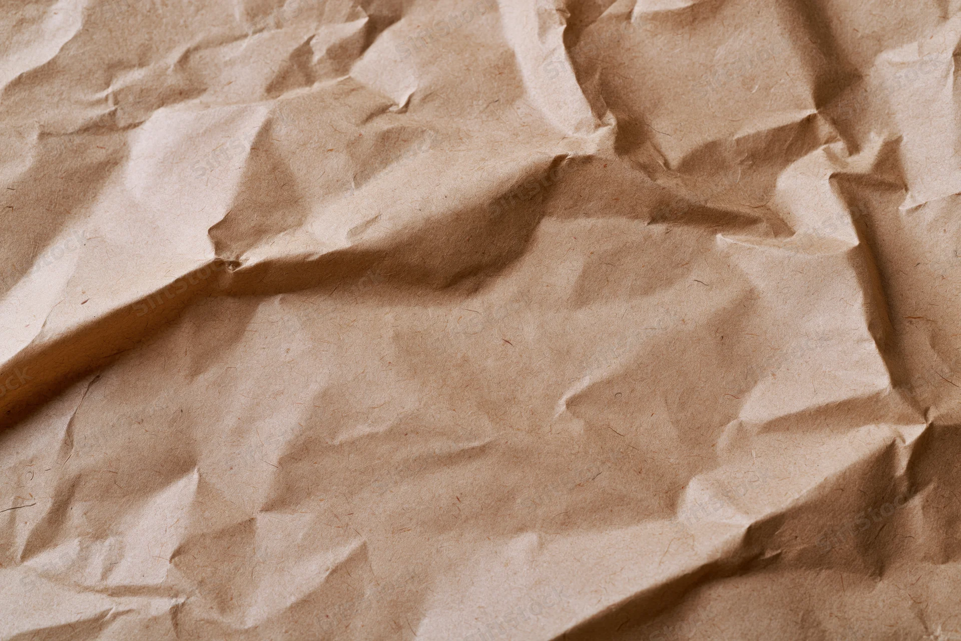 Crumpled brown kraft paper surface in close-up flat lay view