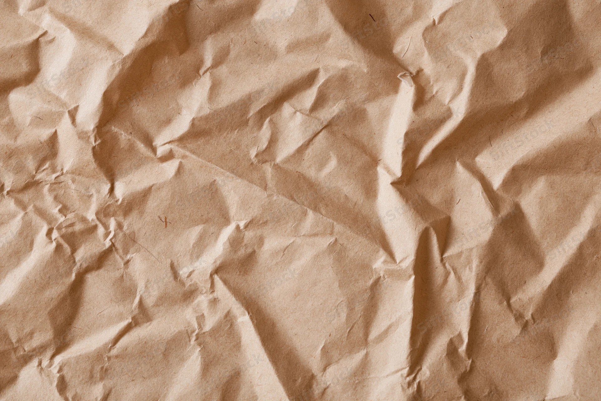 Close-up of crumpled brown kraft paper surface in flat lay arrangement