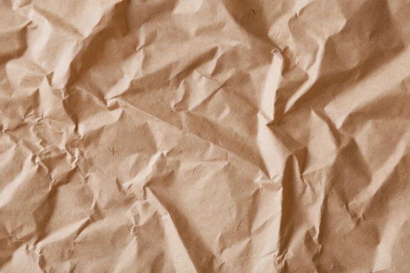 Close-up of crumpled brown kraft paper surface in flat lay arrangement