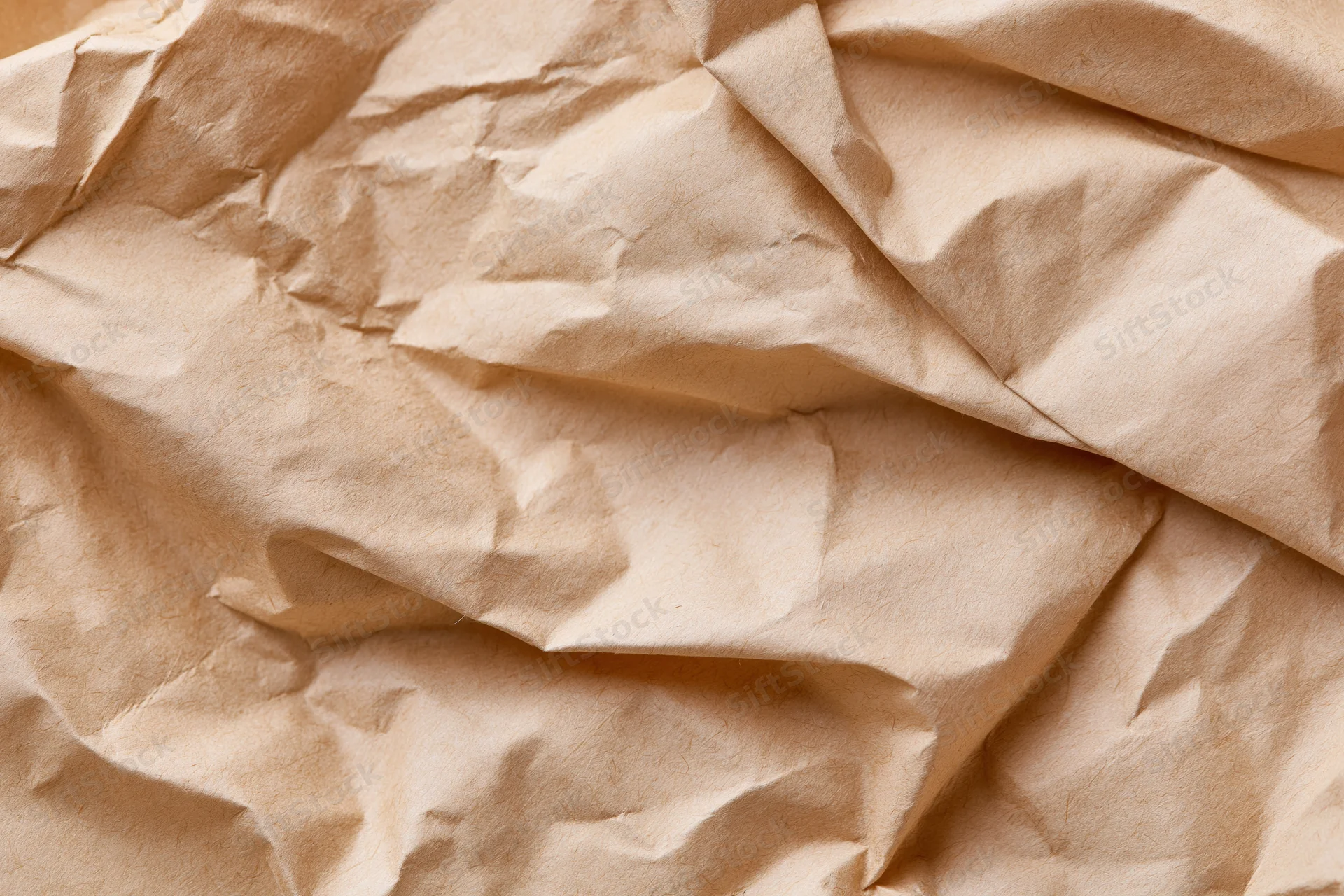 Crumpled brown kraft paper filling the frame as a textured surface