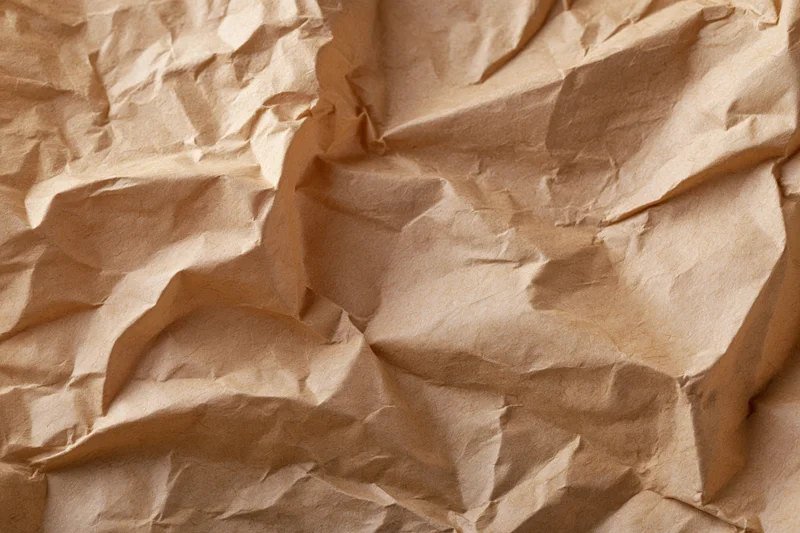 Crumpled recycled kraft brown paper texture in flat lay closeup