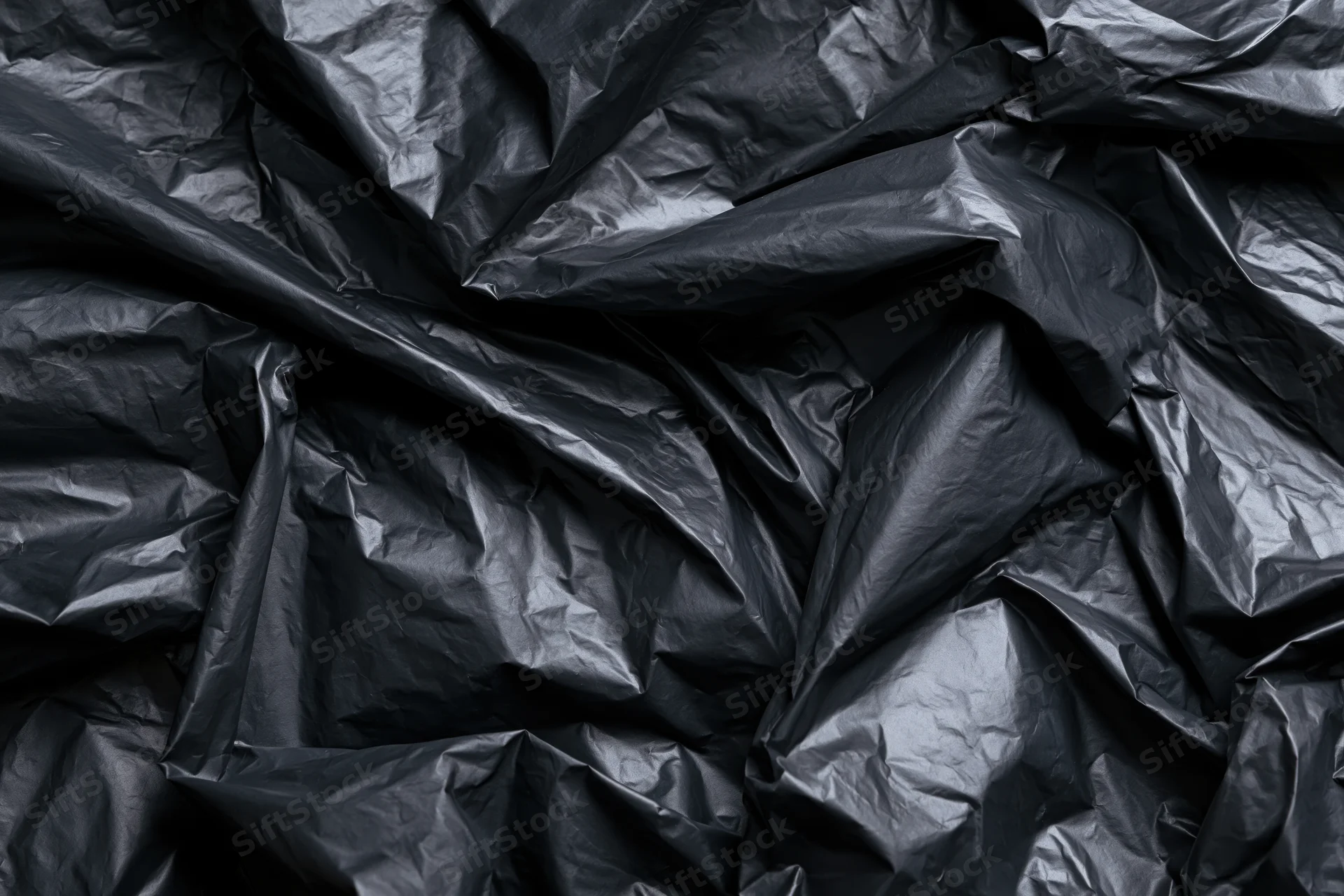 Crumpled black plastic sheeting in close-up flat lay view