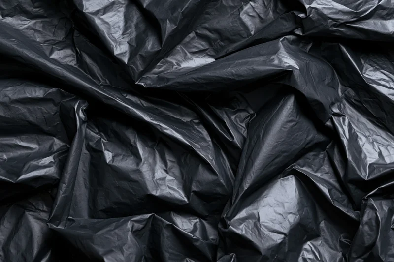 Crumpled black plastic sheeting in close-up flat lay view
