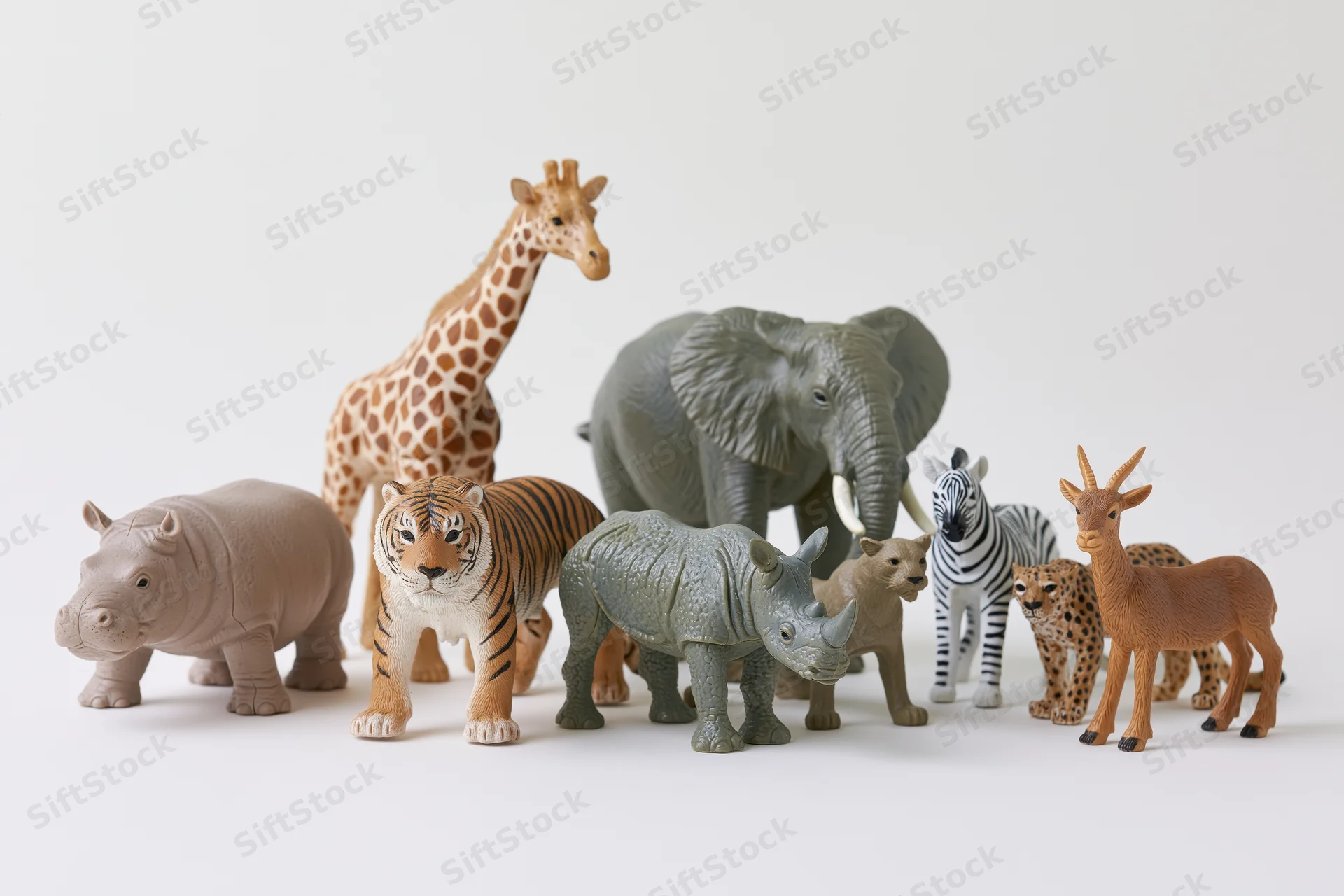 Plastic safari animal figurines arranged in a group on a white surface